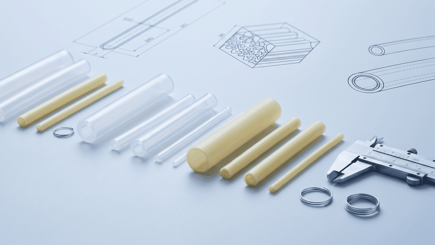 Illustration of clear and pale-yellow tubing samples with schematic cross-sections and a caliper on a light-blue drafting surface